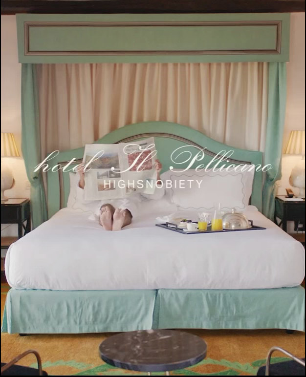 Woman in white dress and gold earrings walking down runway